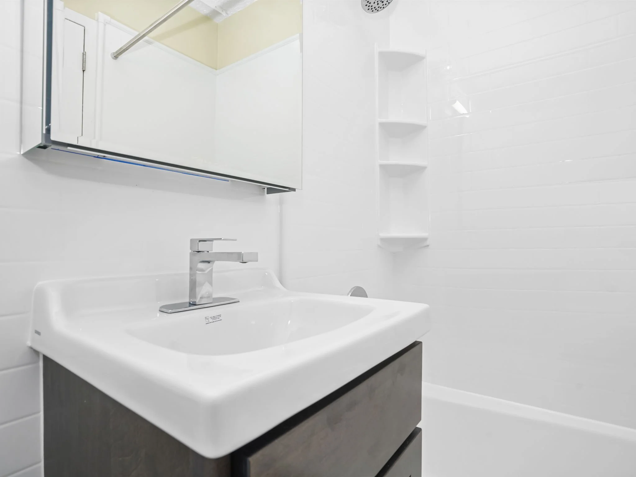 Finished apartment bathroom with a seamless white wall system in an occupied multifamily building